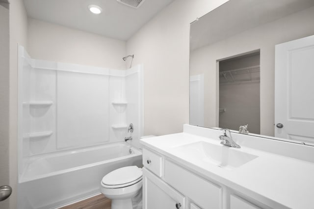 bathroom featuring toilet,  shower combination, wood finished floors, and vanity