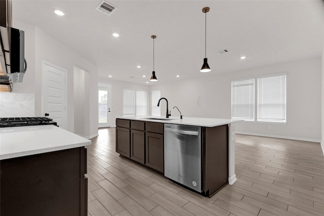 kitchen with visible vents, wood finish floors, light countertops, appliances with stainless steel finishes, and a sink