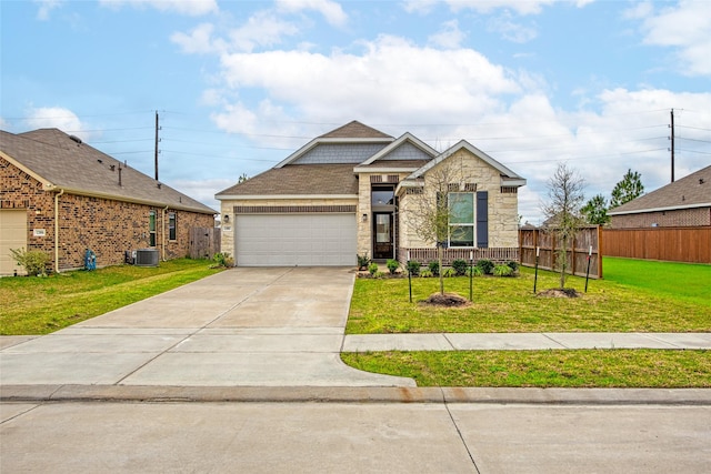 view of front of home featuring cooling unit, fence, driveway, a front lawn, and stone siding