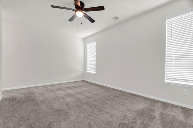 unfurnished room with visible vents, baseboards, a ceiling fan, and carpet flooring