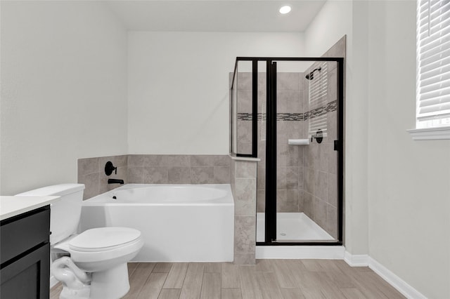 full bath featuring wood finish floors, a garden tub, toilet, a stall shower, and vanity