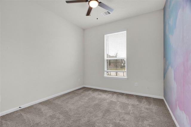 carpeted empty room with visible vents, a ceiling fan, and baseboards