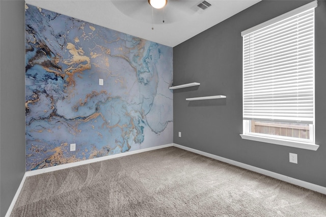 spare room featuring visible vents, baseboards, carpet, and a ceiling fan