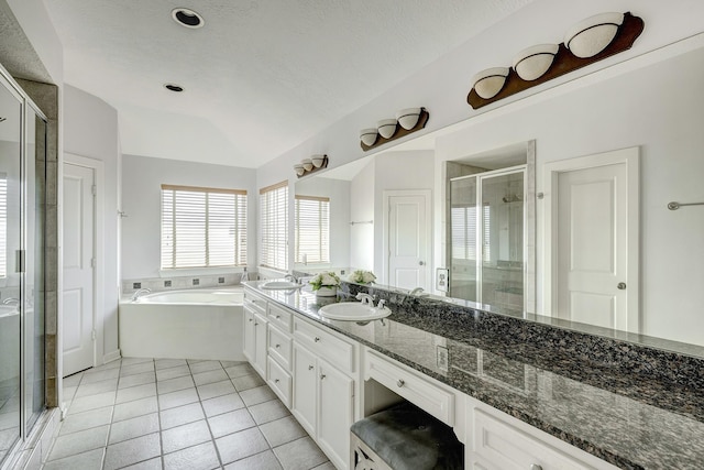 full bathroom featuring a stall shower, tile patterned flooring, a garden tub, and vanity