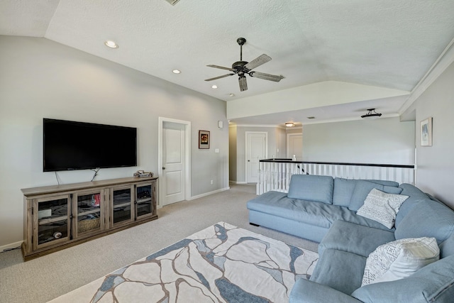 living area featuring a textured ceiling, light carpet, a ceiling fan, baseboards, and vaulted ceiling