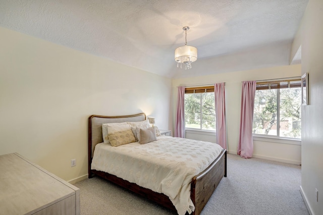 bedroom with light carpet, vaulted ceiling, a textured ceiling, and baseboards