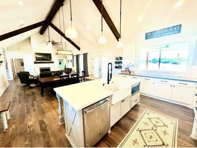 kitchen with a fireplace, appliances with stainless steel finishes, dark wood finished floors, and a sink