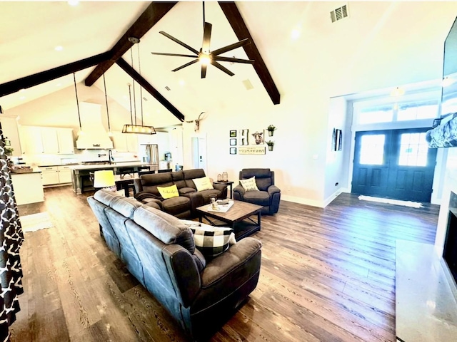 living area featuring high vaulted ceiling, dark wood finished floors, visible vents, and beamed ceiling