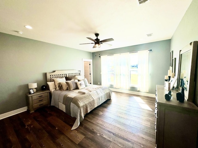 bedroom with dark wood-style floors, visible vents, ceiling fan, and baseboards