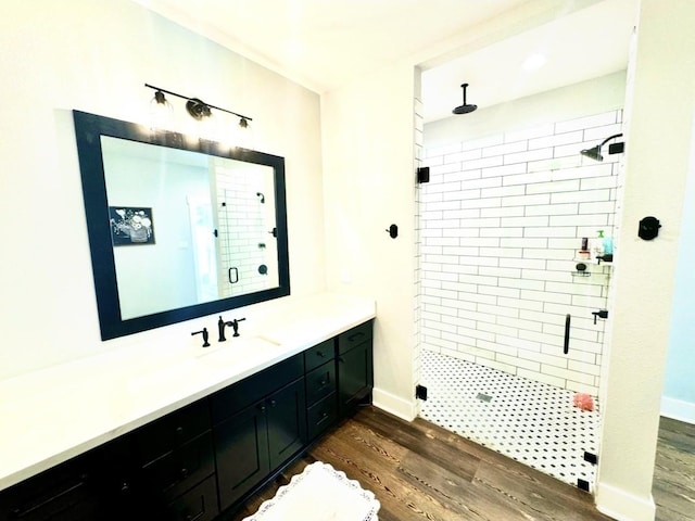 full bath featuring a stall shower, baseboards, wood finished floors, and vanity