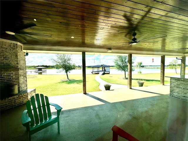 view of property's community with a patio area, a lawn, and a water view