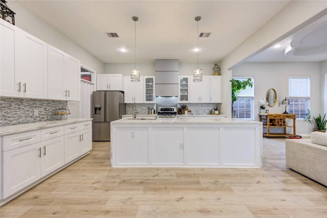 kitchen featuring glass insert cabinets, range, stainless steel fridge with ice dispenser, and light wood finished floors