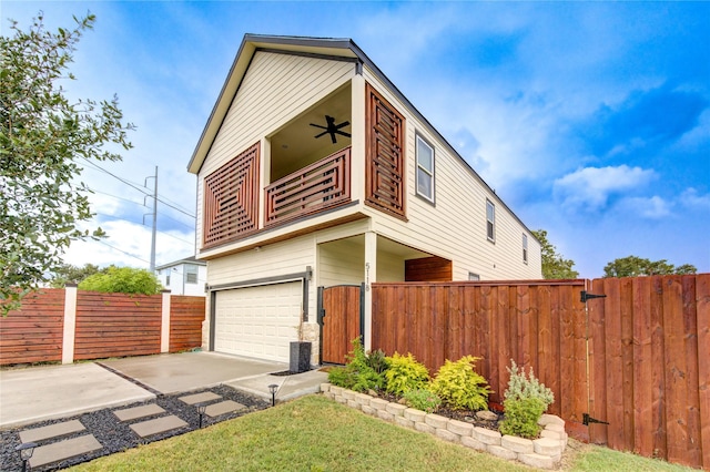 view of front of house featuring a garage, ceiling fan, concrete driveway, and fence