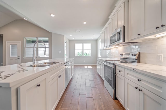 248 Alleda, Prairie View, TX 77484 - kitchen featuring appliances with stainless steel finishes, tasteful backsplash, white cabinets, light stone countertops, and recessed lighting