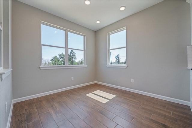 spare room featuring recessed lighting, dark wood-style flooring, and baseboards