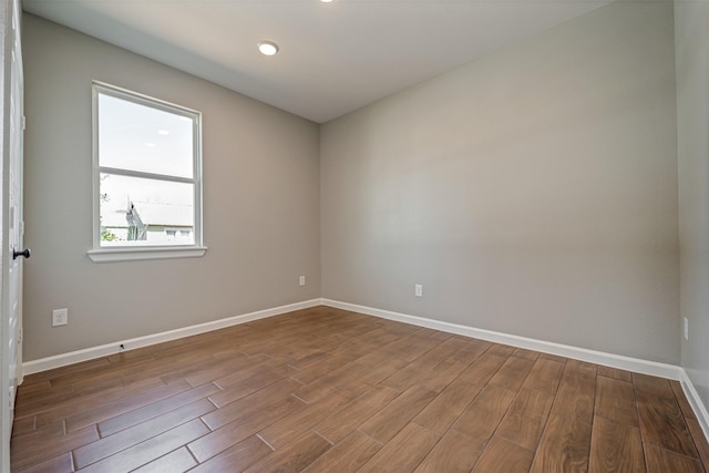 unfurnished room featuring baseboards and wood finished floors