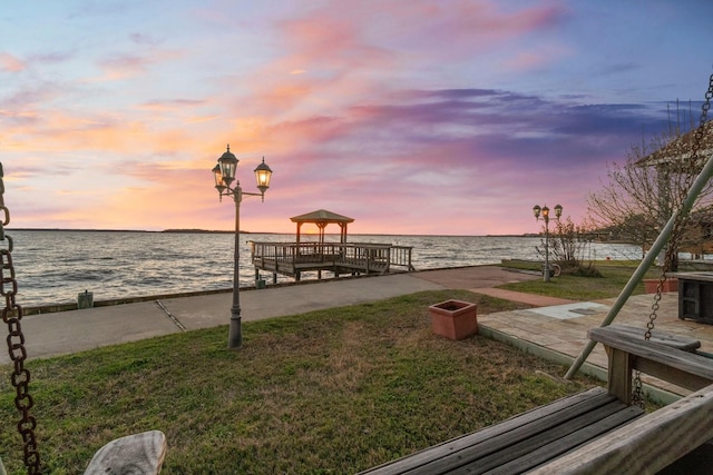 dock area featuring a water view and a yard