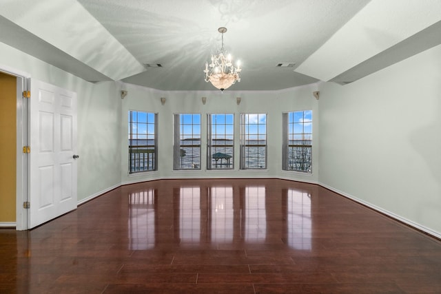 spare room with wood finished floors, visible vents, and a healthy amount of sunlight