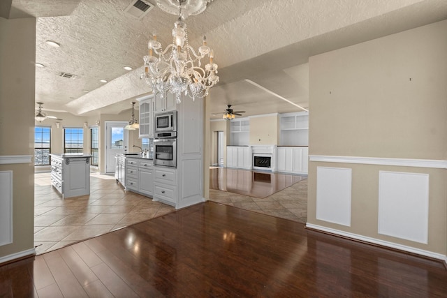 interior space featuring stainless steel appliances, visible vents, light wood-style floors, and a textured ceiling