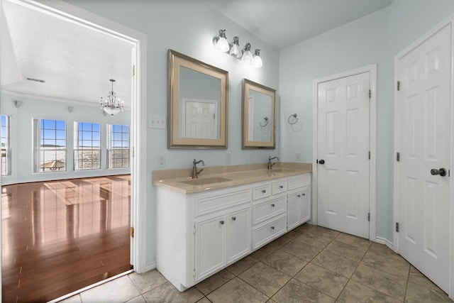 bathroom featuring double vanity, tile patterned floors, a sink, and a notable chandelier