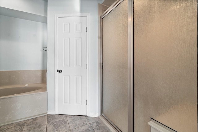 bathroom featuring a stall shower and a garden tub