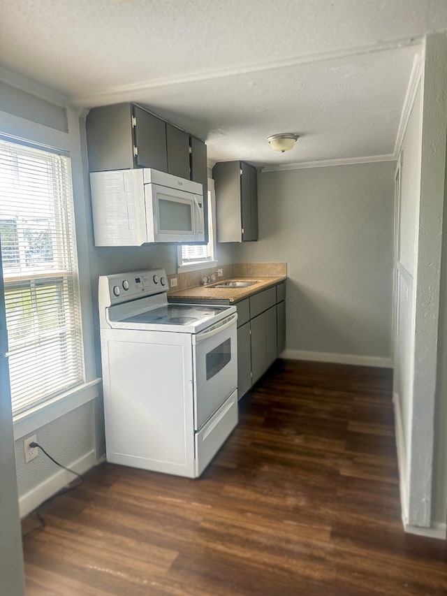 kitchen with white appliances, baseboards, dark wood-type flooring, and a sink