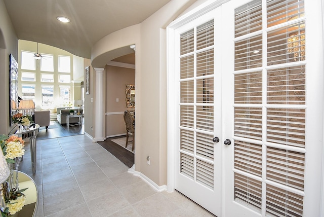 hall with arched walkways, recessed lighting, ornate columns, light tile patterned flooring, and baseboards