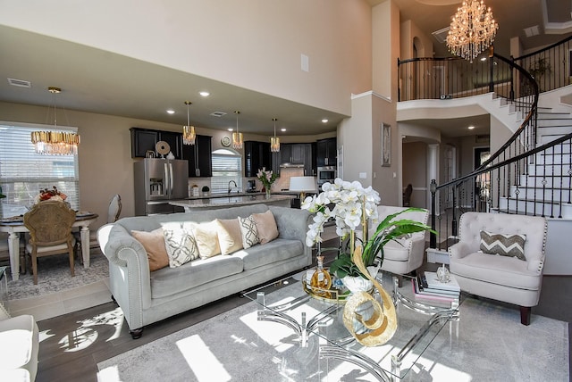 living area with arched walkways, visible vents, stairway, and an inviting chandelier