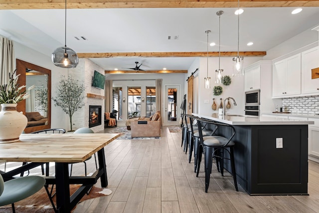 kitchen with stainless steel appliances, a sink, visible vents, light wood-style floors, and open floor plan