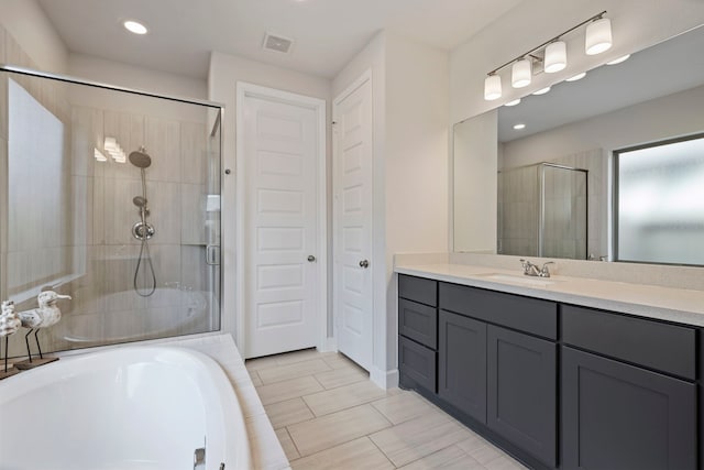 bathroom featuring a bathtub, recessed lighting, visible vents, a stall shower, and vanity