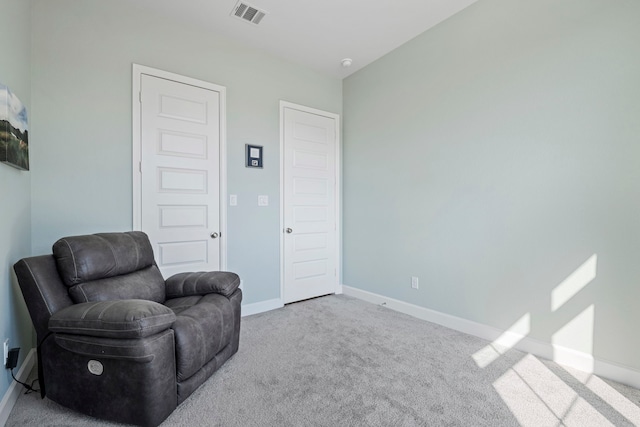 sitting room featuring carpet floors, visible vents, and baseboards