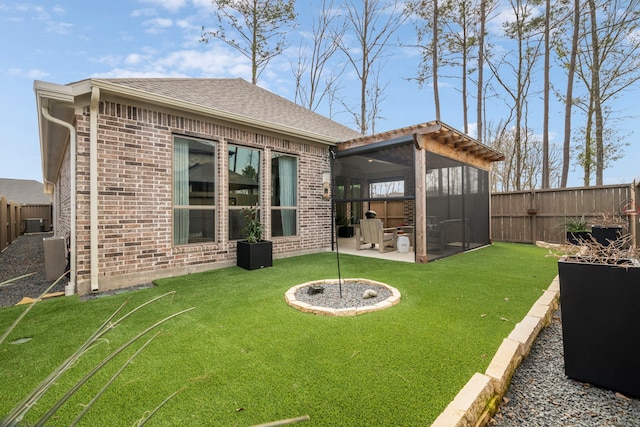 back of property featuring a fenced backyard, a lawn, a patio, and brick siding