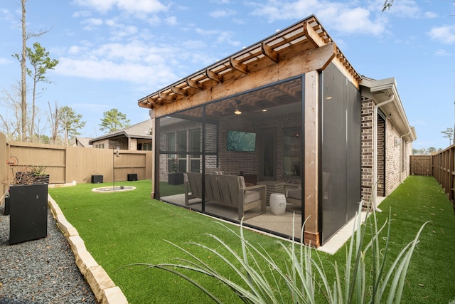 back of house featuring a sunroom, a fenced backyard, a yard, a patio area, and brick siding