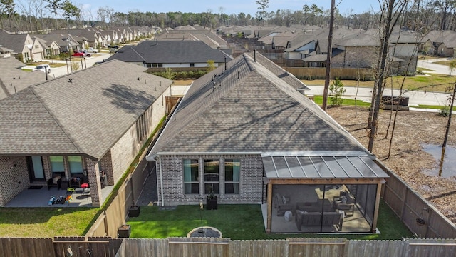 back of property with a shingled roof, a lawn, a patio area, a residential view, and a fenced backyard