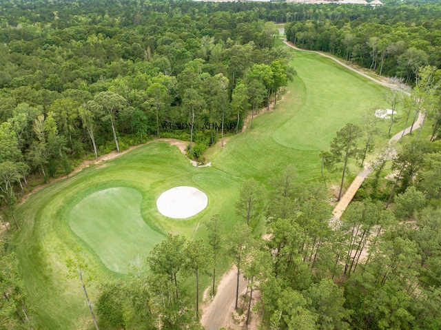 birds eye view of property with view of golf course and a wooded view