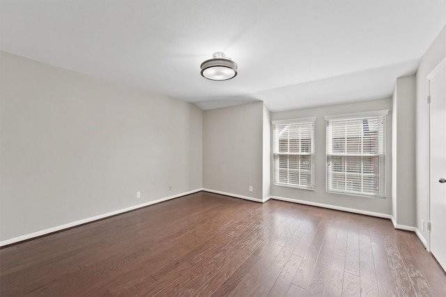 empty room with dark wood-style floors and baseboards