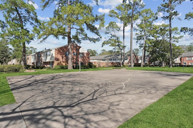 exterior space featuring a residential view, community basketball court, and a front yard