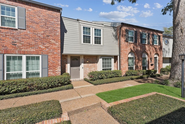 view of front of property featuring a front yard and brick siding