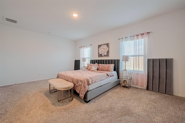 bedroom featuring carpet flooring, multiple windows, baseboards, and visible vents