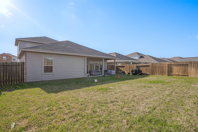 back of house featuring a yard and a fenced backyard