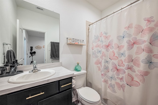 bathroom with visible vents, toilet, and vanity