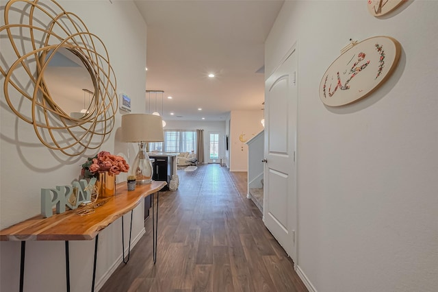 hallway with recessed lighting, baseboards, and dark wood-type flooring