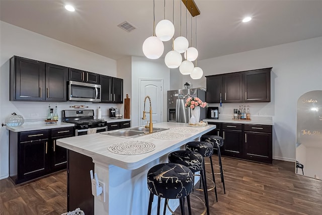 kitchen with a sink, light countertops, dark wood-style flooring, and stainless steel appliances