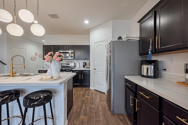 kitchen with visible vents, a sink, dark wood-style floors, stainless steel appliances, and light countertops