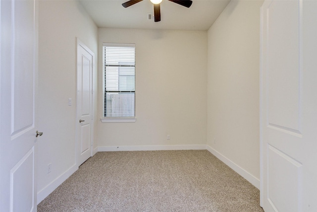 empty room with baseboards, light colored carpet, and a ceiling fan