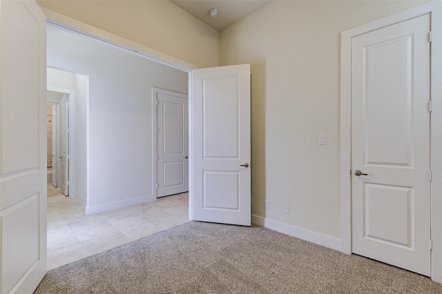 unfurnished bedroom with light colored carpet and baseboards