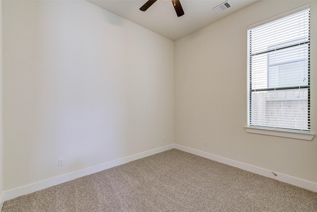 unfurnished room featuring baseboards, light colored carpet, visible vents, and ceiling fan