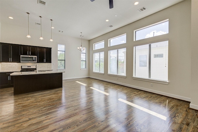 kitchen featuring dark wood-style floors, visible vents, baseboards, appliances with stainless steel finishes, and ceiling fan with notable chandelier