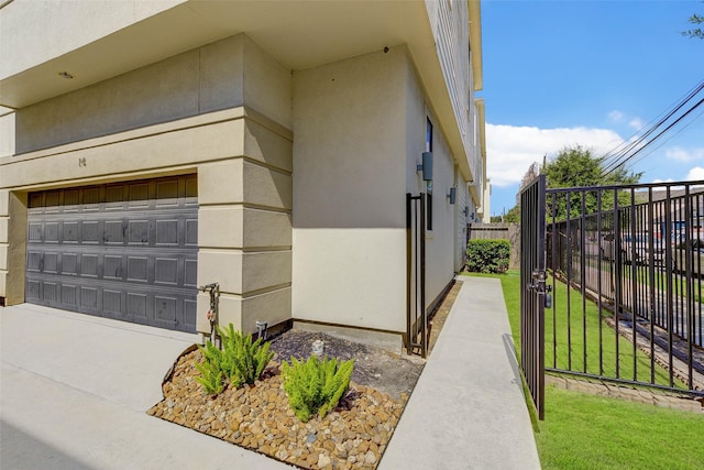 view of home's exterior with stucco siding and fence