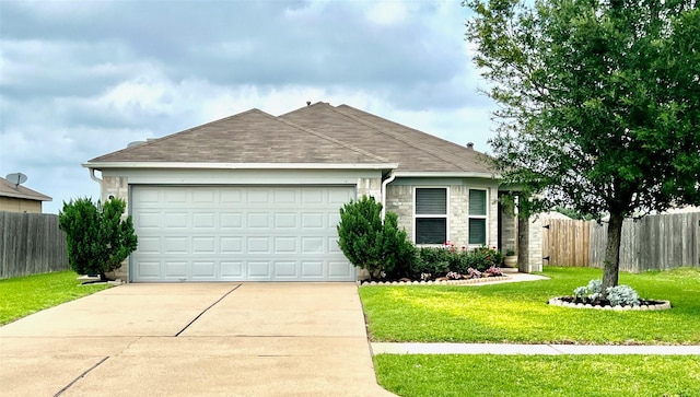 ranch-style home featuring driveway, roof with shingles, an attached garage, fence, and a front yard